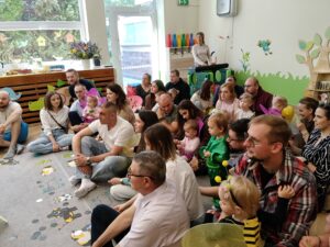 Dzieci siedzą u rodziców na kolankach i uważnie oglądają krótkie przedstawienie z udziałem cioć z grupy.