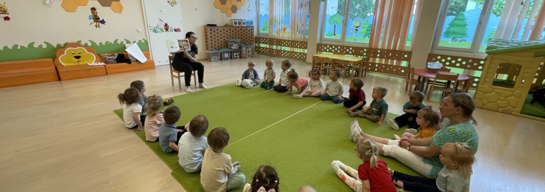 Pani z biblioteki czyta dzieciom bajkę.