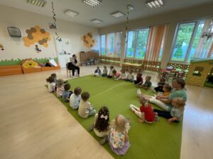 Pani z biblioteki czyta dzieciom bajkę.