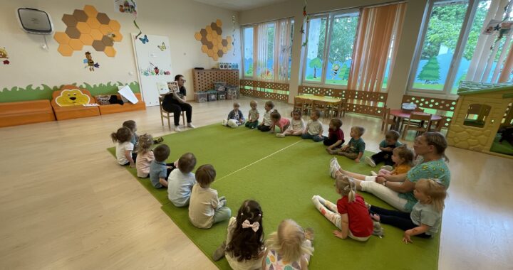 Pani z biblioteki czyta dzieciom bajkę.