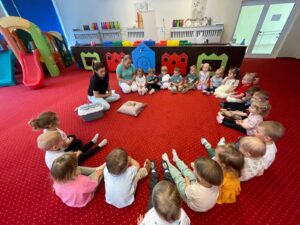 Dzieci podczas warsztatów przyrodniczych poznają agamę brodatą, obserwują ją z bliska i uczestniczą w zajęciach edukacyjnych w sali żłobkowej.