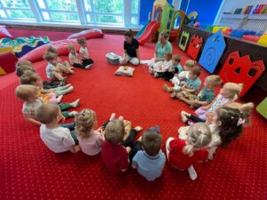 Dzieci podczas warsztatów przyrodniczych poznają agamę brodatą, obserwują ją z bliska i uczestniczą w zajęciach edukacyjnych w sali żłobkowej.