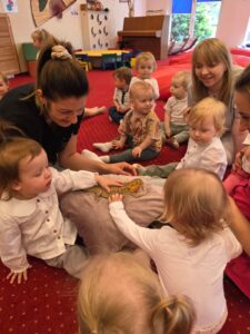 Dzieci podczas warsztatów przyrodniczych poznają agamę brodatą, obserwują ją z bliska i uczestniczą w zajęciach edukacyjnych w sali żłobkowej.