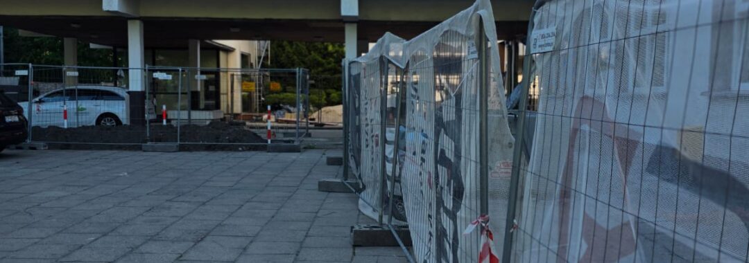 Wygrodzony teren prac remontowych na dziedzińcu żłobka z wyznaczonym ciągiem komunikacyjnym dla użytkowników obiektu.