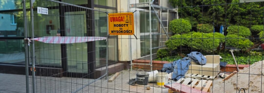 Wygrodzony teren prac remontowych na dziedzińcu żłobka z wyznaczonym ciągiem komunikacyjnym dla użytkowników obiektu.