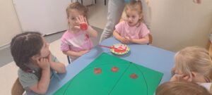 Dziewczynka odbija dłoń pomalowaną czerwoną farbą