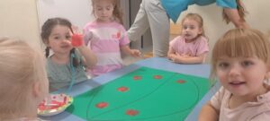 Dziewczynka odbija dłoń pomalowaną czerwoną farbą