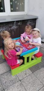 Dzieci bawią się piankoliną w ogrodzie