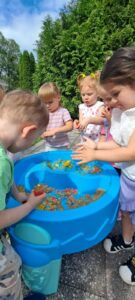 Dzieci bawią się piaskiem kinetycznym w ogrodzie