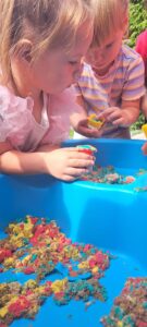 Dzieci bawią się piaskiem kinetycznym w ogrodzie