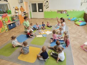dzieci siedzą w kole i słuchają, jakie ubrania ubieramy latem