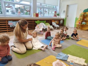 dzieci siedzą w kole i słuchają, jakie ubrania ubieramy latem