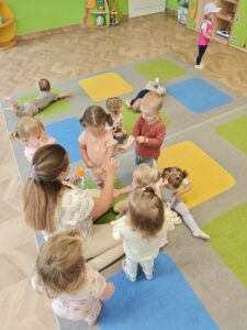 opiekun nakłada dzieciom na rączkę po kropce kremu z filtrem