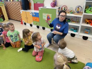 Pani z biblioteki czyta książkę dzieciom.