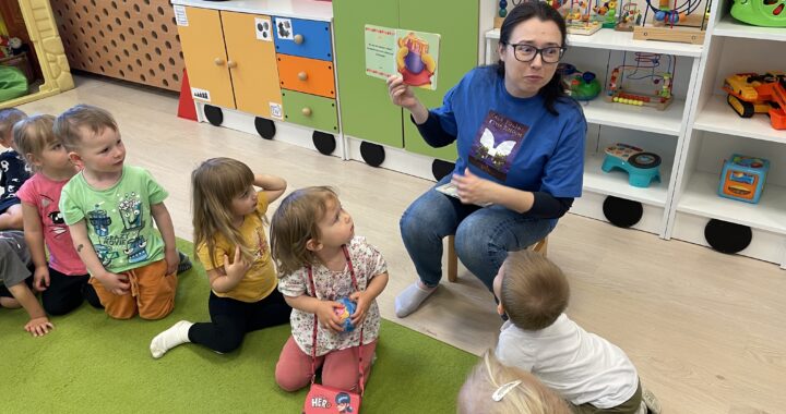 Pani z biblioteki czyta książkę dzieciom.