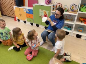 Pani z biblioteki czyta książkę dzieciom.