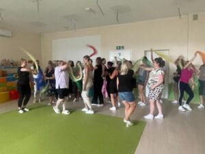 Kadra żłobka bierze udział w szkoleniu muzycznym, bawiąc się kolorowymi