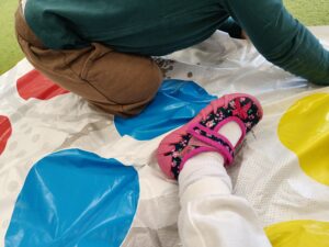 Chłopiec bawi się na planszy do gry "Twister".
