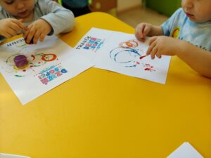Dzieci tworzą kropeczkowe prace plastyczne.