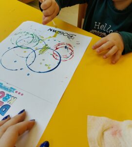 Dzieci tworzą pracę plastyczna. Robią kropeczki patyczkiem kosmetycznym zamoczonym w farbie.