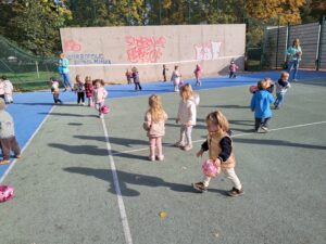 Dzieci bawią się piłkami na korcie tenisowym