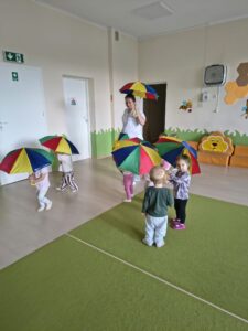 Dzieci maszerują w rytm muzyki klasycznej w sali.