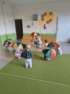 Dzieci tańczą jesienny taniec z parasolami.