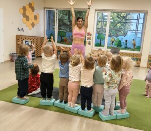 Dzieci próbują utrzymać równowagę stojąc na kostkach.