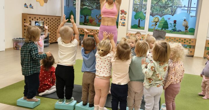 Dzieci próbują utrzymać równowagę stojąc na kostkach.